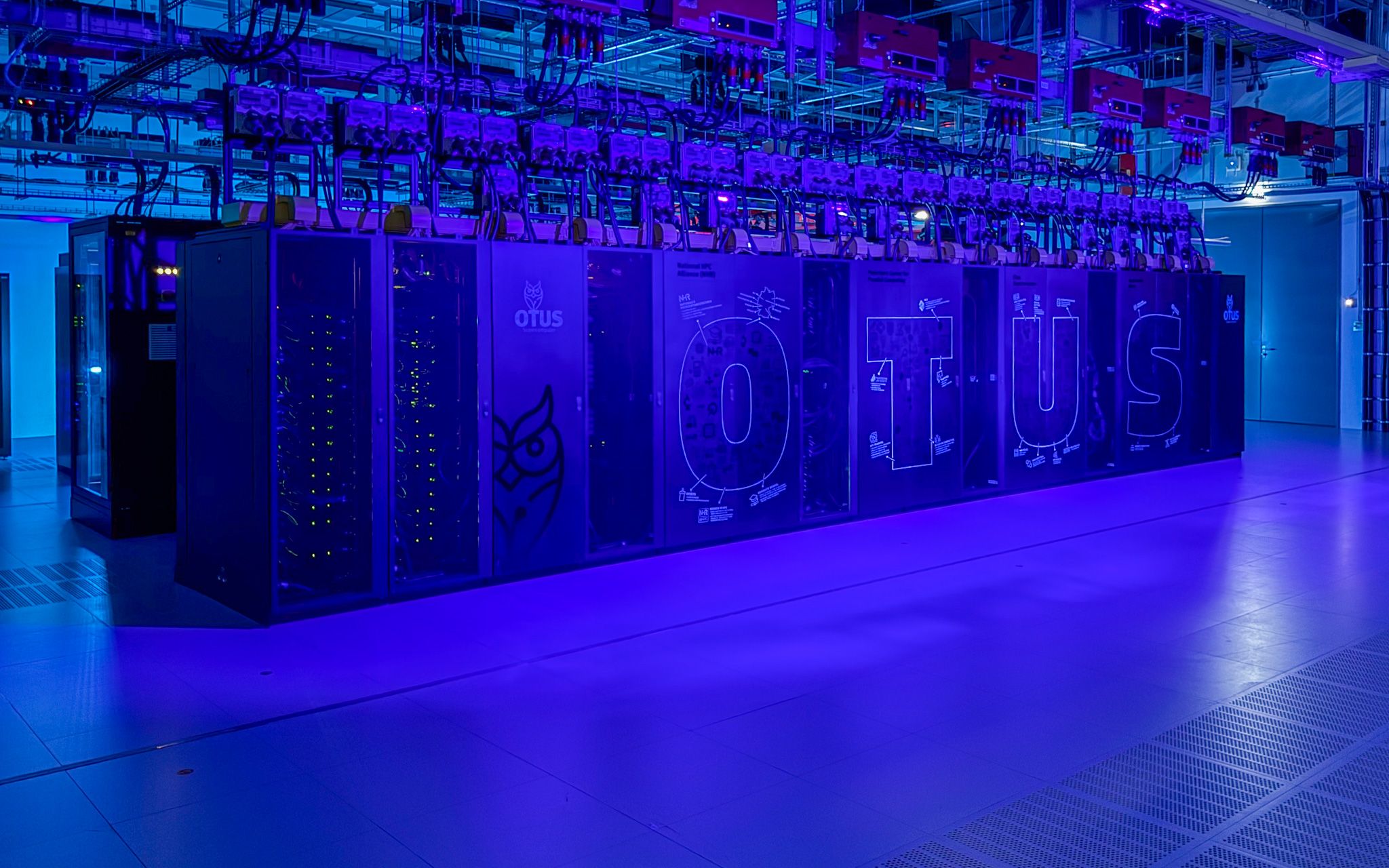 Blick in den inszenierten Rechencluster im PC2 in Paderborn mit violettem Licht und Server-Racks.